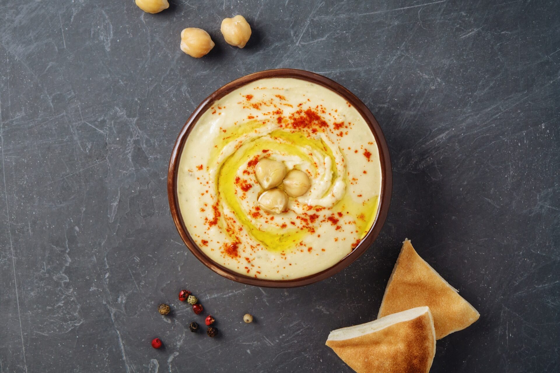 traditional-chickpea-hummus-bowl-with-pita-flatbread-chickpeas-spices-gray-background